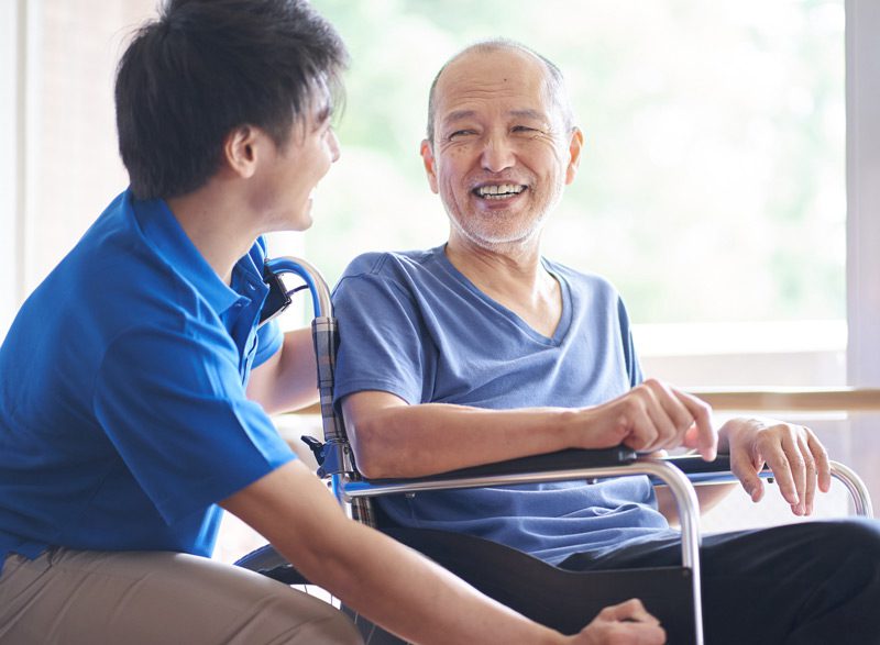 Home-health-aide-interacting-with-elderly-man